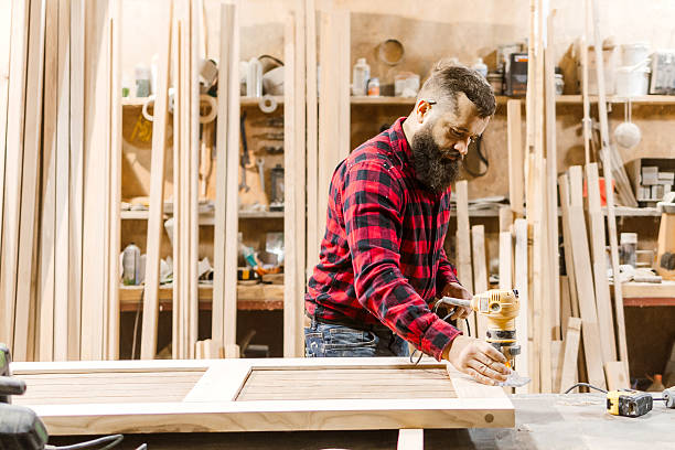 istock Skilled carpenter using a router to craft wooden panels in a well-equipped workshop environment 2212595138