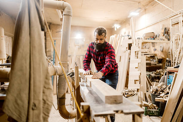 istock Craftsman operates woodworking machinery in workshop during daylight hours 2212597557