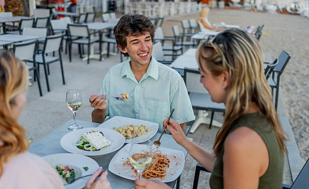 istock Friends enjoying a meal together at a beachfront restaurant 2212598494