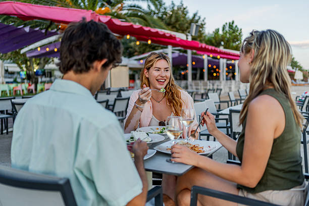 istock Friends enjoying dinner at beach restaurant with white wine 2212598622