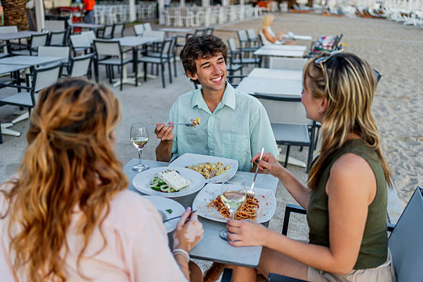 istock Friends enjoying a beachside meal together at a restaurant 2212599042