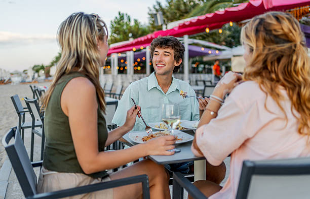 istock Friends enjoying a beachside meal at sunset 2212599113