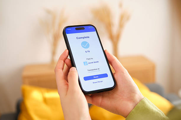 istock Woman completing online transaction using mobile phone at home 2212600281