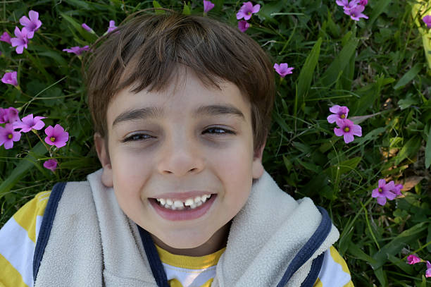 kid smiling outside among the flowers