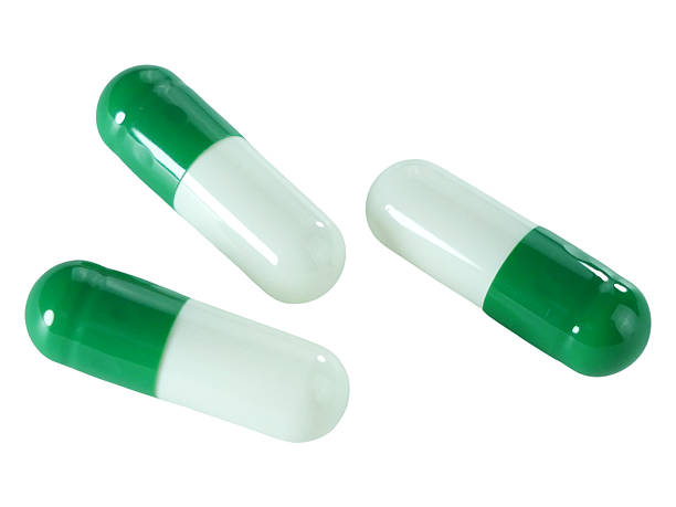 istock Bulk green and white capsule pills isolated on white background. 2212601005