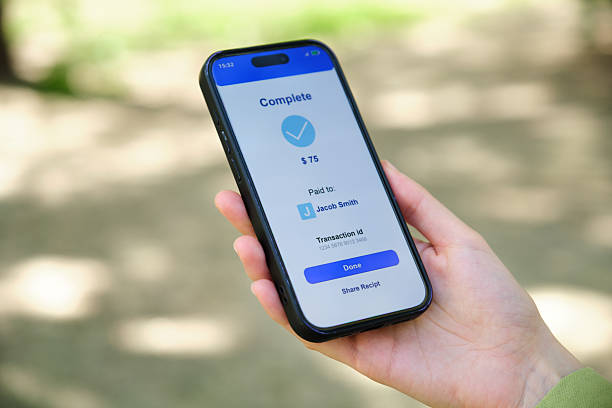 istock Woman holding smartphone displaying successful mobile payment confirmation screen 2212601179