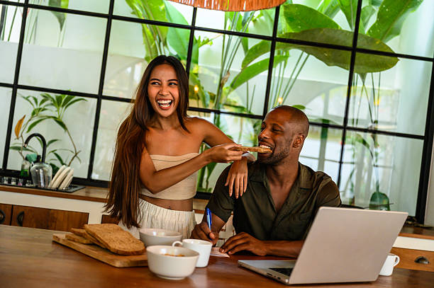 Happy couple sharing a light breakfast in a modern kitchen with greenery ambiance