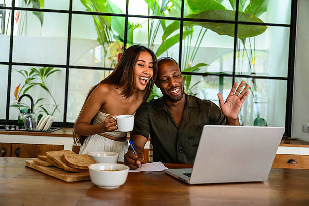 istock Happy couple video chatting during breakfast in a modern kitchen setting 2212601615