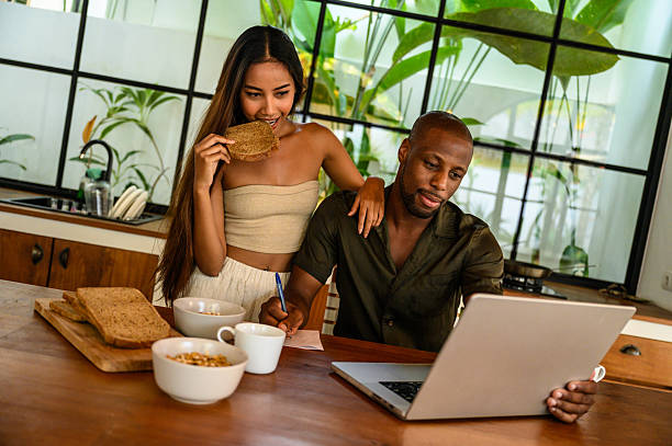 istock Couple enjoying breakfast while working on a laptop in a modern kitchen 2212601619