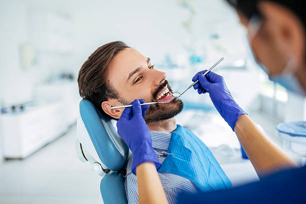 istock Smiling Woman Dentist in Uniform Treating Patient 2212601687