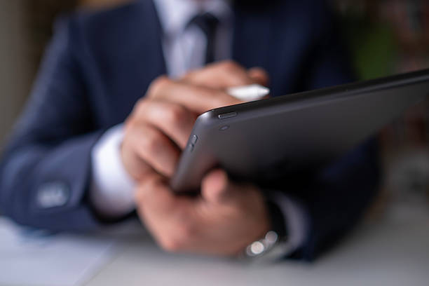 istock Businessman  working at desk using laptop computer and digital tablet.Business man hands holding tablet. 2212601855