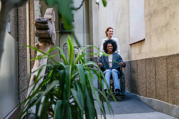 istock Coworkers navigating accessibility ramp with a wheelchair 2212602071
