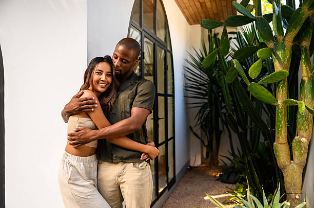 istock Happy couple embracing outdoors near a modern home surrounded by vibrant greenery 2212603548