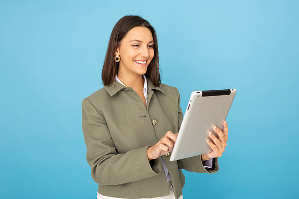 istock Professional businesswoman smiling, working on digital tablet in studio setting 2212604652