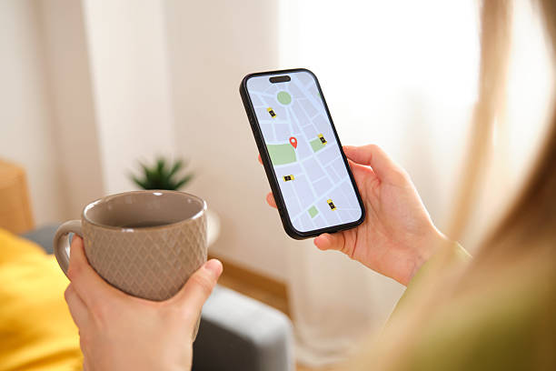 istock Woman using a rideshare app on her phone while drinking coffee at home 2212604881