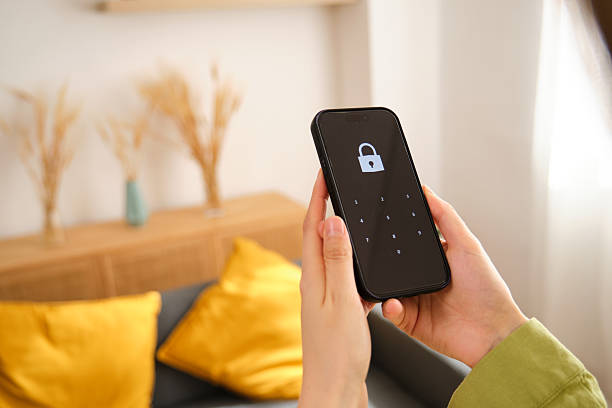 istock Woman unlocking smartphone with password at home 2212604941