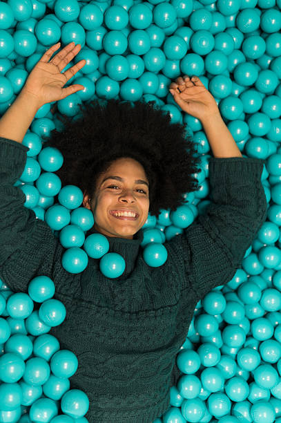 istock Young woman lying down and having fun in a ball pit 2212605014