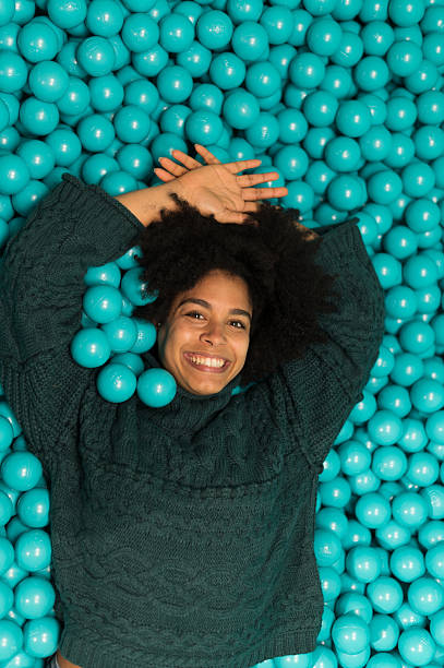 istock Young woman lying down and having fun in a ball pit 2212605018