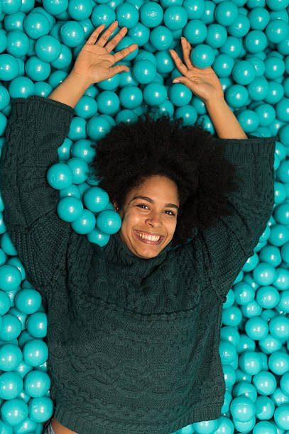 istock Young woman lying down and having fun in a ball pit 2212605036