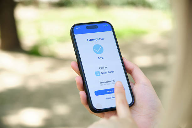 istock Woman completing mobile payment on smartphone outdoors 2212605110