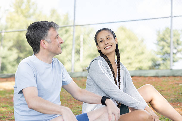 A joyful couple embraces health and connection while participating in an outdoor yoga session