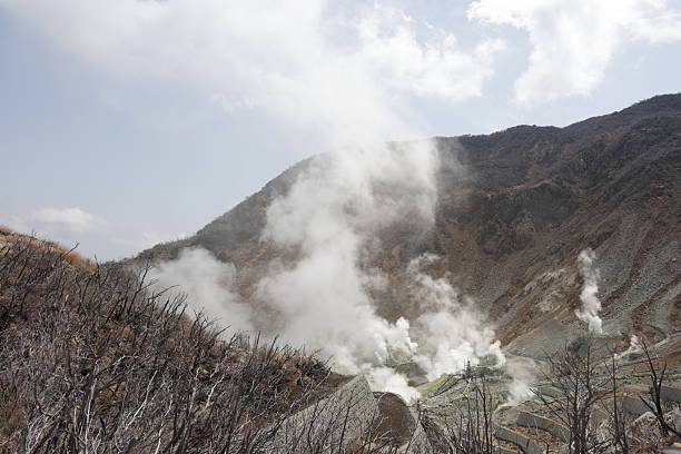 A rocky surface partially obscured by thick white smoke or fog, creating a mysterious and ethereal atmosphere