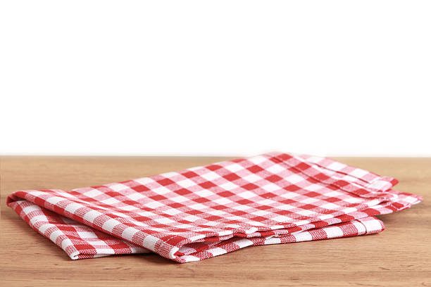 istock Red checkered kitchen towel on wooden table 2212610975