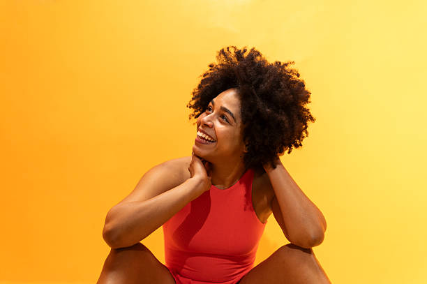 istock Woman smiling and looking up on yellow background 2212615498