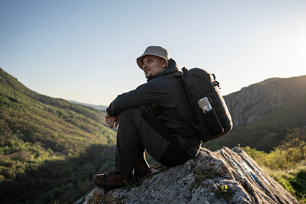 istock Male Hiker Relaxing on a Mountain Rock During Sunset Adventure 2212617100
