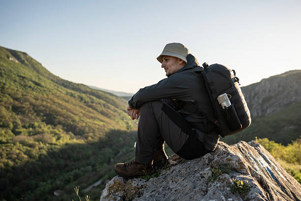 istock Man Enjoying Serene Nature While Hiking in a Scenic Mountainous Landscape 2212617103