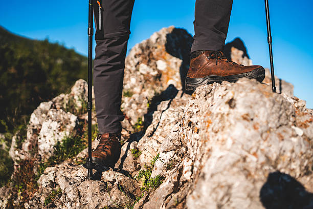 istock Hiker Traversing Rocky Terrain With Trekking Gear Under Clear Blue Sky 2212617199