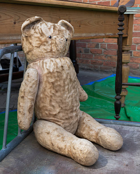 istock Vintage teddy bear sitting on the floor indoors 2212617800