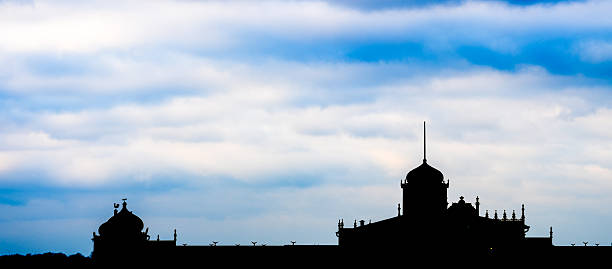 Silhouette of historical building under dramatic sky.