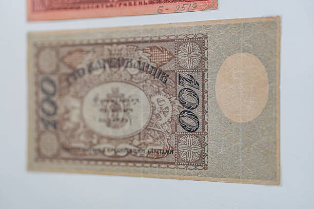 istock Historical, aged Ukrainian banknote pasted on a surface Features a portrait and intricate patterns in blues, greens, purples, and yellows Shows both left and right sides with 3D effect under natura 2212621897