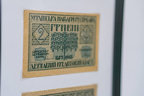 Historical, aged Ukrainian banknote pasted on a surface Features a portrait and intricate patterns in blues, greens, purples, and yellows Shows both left and right sides with 3D effect under natura