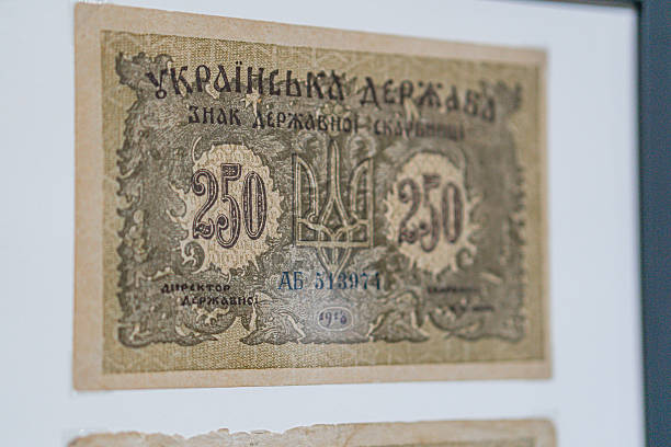 Historical, aged Ukrainian banknote pasted on a surface Features a portrait and intricate patterns in blues, greens, purples, and yellows Shows both left and right sides with 3D effect under natura