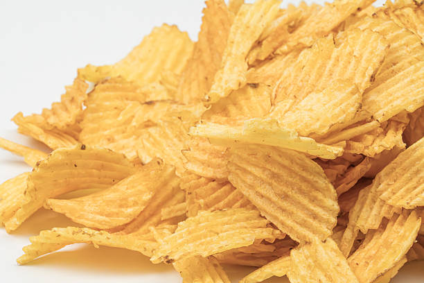 istock Golden-brown potato chips on a white surface, varying sizes and shapes, bright lighting with soft shadows, no distracting objects, slightly elevated perspective, realistic style 2212623374