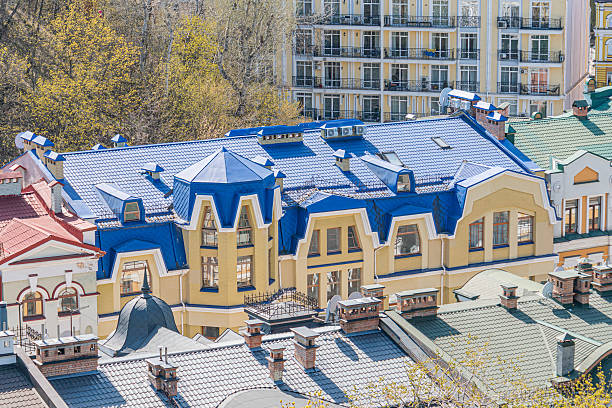 This image presents a multi-story, architecturally intricate building with a yellow and blue facade, resembling European styles like Art Nouveau or Folk Romanticism The building boasts decorative ea
