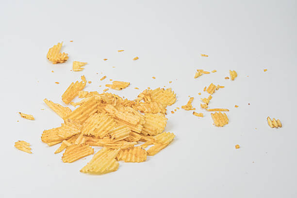 istock A pile of yellow potato chips, varying in size and shape, scattered on a flat surface under soft shadows cast by an overhead light source 2212624011