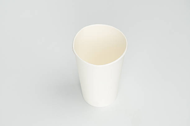 istock A single plastic coffee cup with white lid on a grey surface, containing dark brown frothy liquid. 2212624736