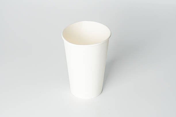 istock A single white ridged paper cup slightly off-center on a light background, with soft shadows from overhead lighting. 2212624813