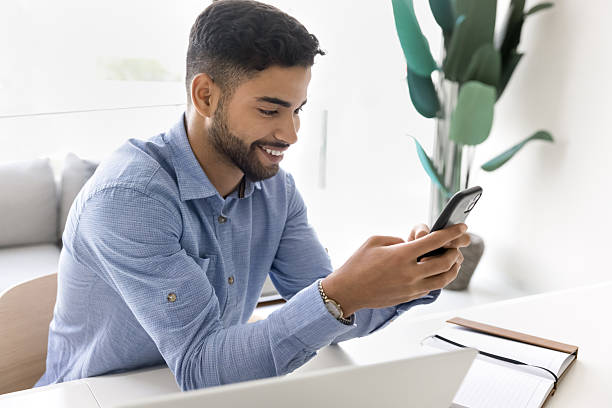 istock Confident happy young male use phone at office desk 2212625897