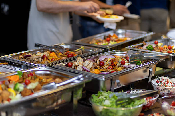 istock Catering buffet featuring assorted colorful vegetables and salads at a gathering with guests serving themselves 2212626544