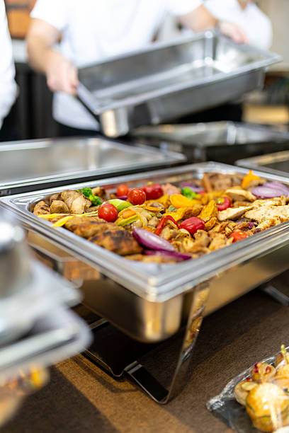 istock Caterers preparing a buffet with grilled vegetables and meats in a modern dining setting 2212626586