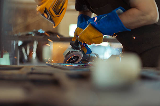 istock Industrial grinding scene – focused worker operating power tool 2212628026