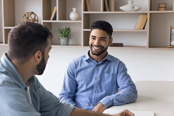 istock Two businessmen workmates having casual conversation at office work desk 2212629074