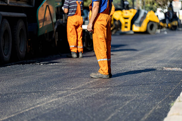 istock Construction workers applying asphalt in a city street during daylight hours 2212629680