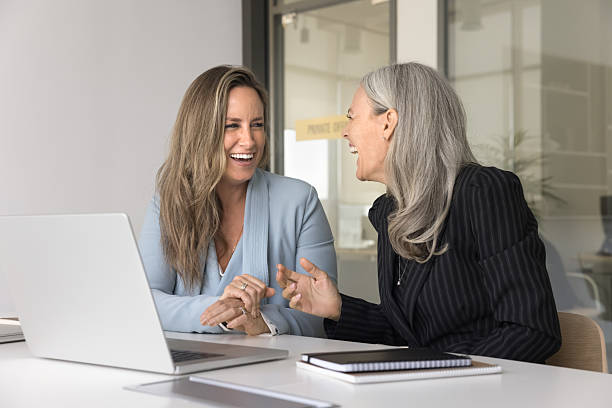 istock Happy laughing female colleagues chatting at workplace distracted from notebook 2212631507