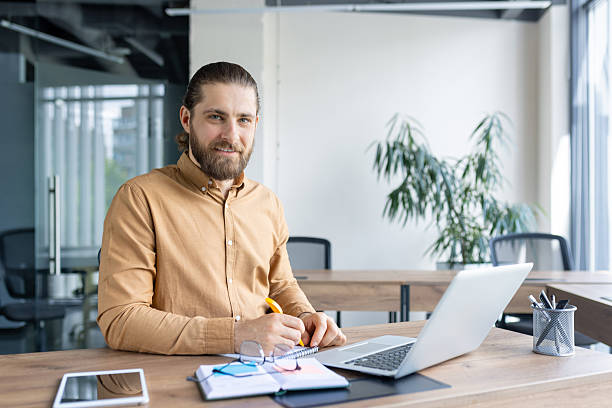 istock Smiling professional working at desk in a modern office environment 2212631731