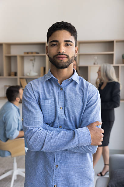 istock Ambitious young businessman looking at camera with arms crossed 2212632096